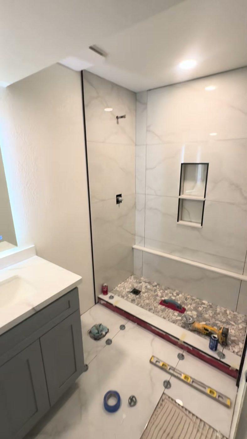 Bathroom remodel in Flagstaff, AZ — tiled shower with niche and gray vanity